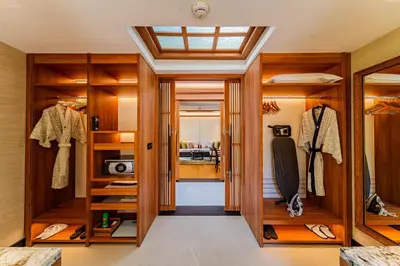 a walk in closet with wooden cabinets and a window at Banyan Tree Phuket in Bang Tao Beach