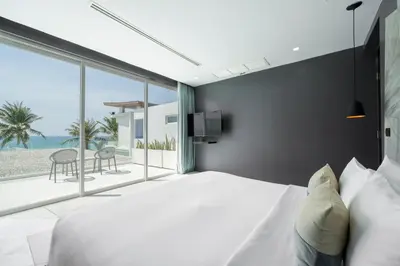 a bedroom with a bed and a view of the beach at Coastal Escape Natai Beach in Natai Beach