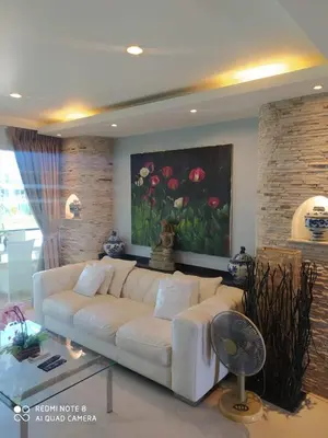 a living room with a white couch and a painting at Karon Beach Apartment Sea View in Karon Beach