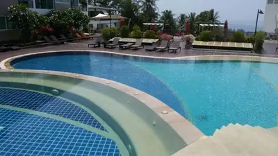 a large swimming pool with blue water in a hotel at Karon Beach Apartment Sea View in Karon Beach