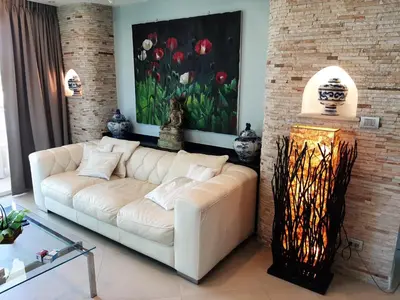 a living room with a white couch and a painting of flowers at Karon Beach Apartment Sea View in Karon Beach