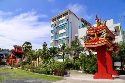 a building with a red statue in front of a building at The BluEco Hotel SHA Plus in Kata Beach