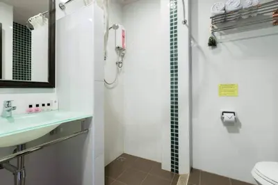 a bathroom with a shower and a sink and a toilet at The BluEco Hotel SHA Plus in Kata Beach