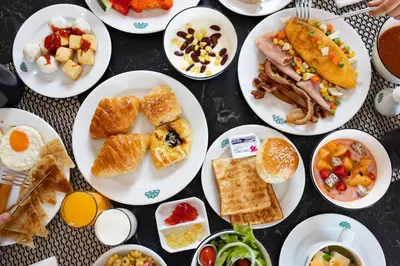 a table with plates of breakfast food on it at The Corner in Patong Beach