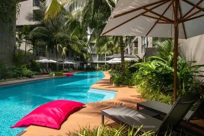a swimming pool with chairs and an umbrella at Diamond Resort Phuket Official Account in Bang Tao Beach
