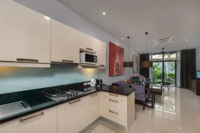 a kitchen with white cabinets and a dining room at VILLA ARU Private Pool 3 min to Naiharn Beach in Nai Harn Beach