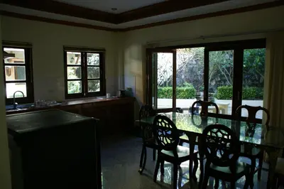 a dining room with a table and chairs and windows at Prince Edouard Apartments & Resort Patong Beach Phuket in Patong Beach