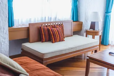 a bench with two pillows on it in a room at Waterfront Suites Phuket by Centara in Karon Beach