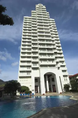 a large white building with a pool in front of it at Waterfront Suites Phuket by Centara in Karon Beach