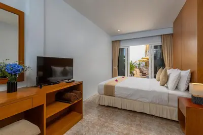 a hotel room with a bed and a television at Kamala Dreams in Kamala Beach