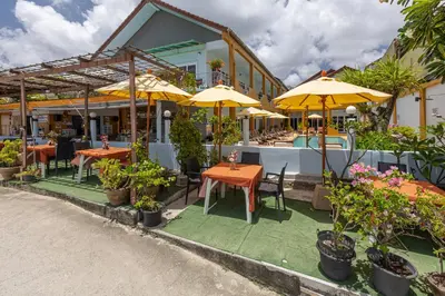 a restaurant with tables and chairs and umbrellas at Kamala Dreams in Kamala Beach