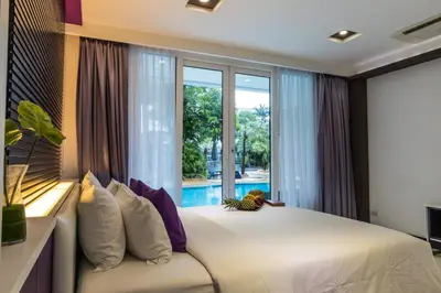 a bedroom with a bed and a large window at The L Resort, Krabi in Ao Nang Beach