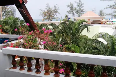 a balcony with plants and flowers on a building at Phuket Golden Sand Inn - SHA Extra Plus in Karon Beach