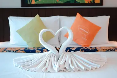 two swans shaped like hearts are on a bed at C & N Resort and Spa - SHA Extra Plus in Patong Beach