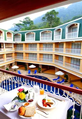 a balcony with a table with food and a hotel at Kalim Resort in Patong Beach