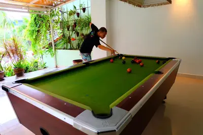 a man playing pool on a pool table at Aonang Top View in Ao Nang Beach