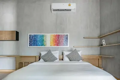 a bedroom with a bed with a rainbow painting on the wall at Woodpecker Villa - Kamala Beach in Kamala Beach