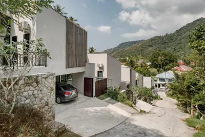 a house with a car parked in a driveway at Woodpecker Villa - Kamala Beach in Kamala Beach