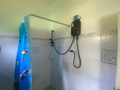 a bathroom with a shower with a blue shower curtain at Sabai Resort in Ao Nang Beach