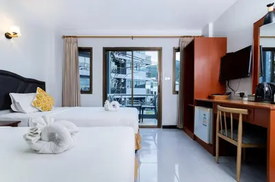 a hotel room with two beds and a desk at Amorn Mansion in Ao Nang Beach