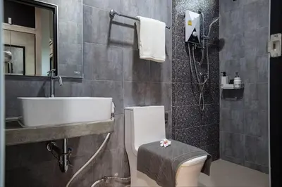 a bathroom with a toilet and a sink and a shower at Be Live Residence in Thalang