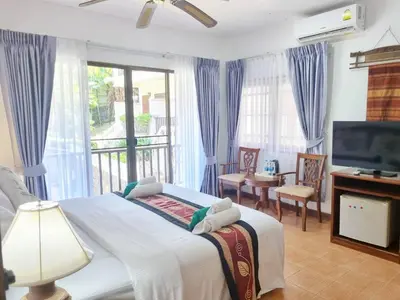 a bedroom with a large bed and a television at Kata Interhouse Resort by Haii Collection in Kata Beach