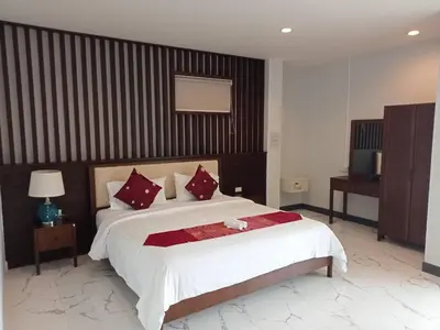 a bedroom with a large bed with red pillows at Da Bungalows in Kata Beach