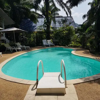 a swimming pool with a bench in a resort at Groovy Bungalows in Ao Nang Beach