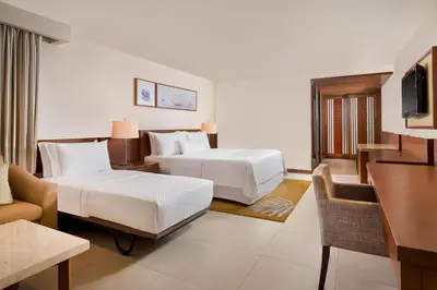 a hotel room with two beds and a desk at The Westin Siray Bay Resort & Spa, Phuket in Phuket Town
