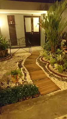 a garden with a wooden walkway in front of a house at Baan Paea Guest House in Ban Ket Ho