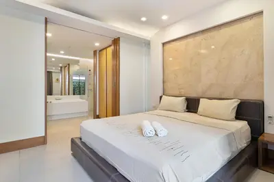 a bedroom with a large bed with two white pillows on it at Nai Thon Beachfront Apartments in Nai Thon Beach