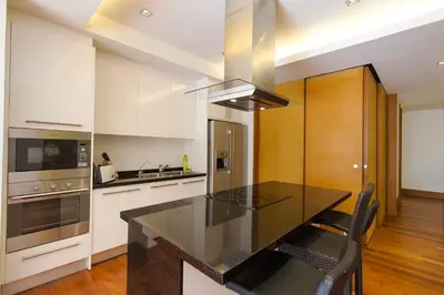 a kitchen with a black counter top and white cabinets at Nai Thon Beachfront Apartments in Nai Thon Beach