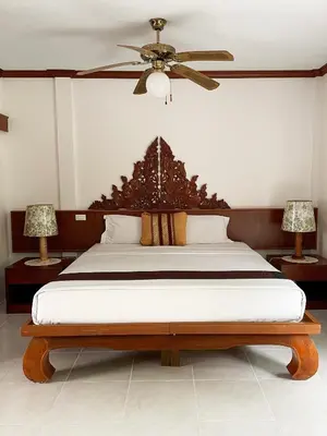 a bedroom with a large bed with a ceiling fan at Patong Palace Hotel - SHA Extra Plus in Patong Beach