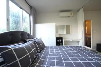 a bedroom with a bed and a large window at Dcondo Kathu Patong Phuket by Suna in Kathu