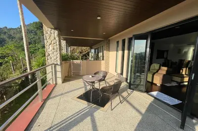a balcony of a house with a table and chairs at Kamala Villa Hill in Kamala Beach