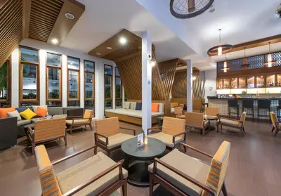 a living room with chairs and a couch and tables at Deevana Plaza Krabi Aonang in Ao Nang Beach