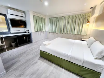 a bedroom with a large bed and a flat screen tv at SEATEL Phuket, Patong Beach in Patong Beach