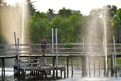 a woman standing on a pier in front of a fountain at Awana Villa Resort Yaonoi - SHA Extra Plus in Ko Yao Noi