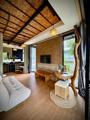a living room with a table and a tree at Awana Villa Resort Yaonoi - SHA Extra Plus in Ko Yao Noi