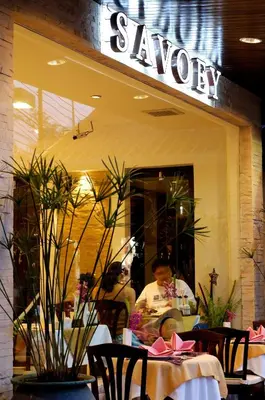 a restaurant with tables and chairs in front of a window at Safari Beach Hotel Patong in Patong Beach