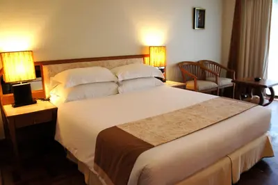 a large bed in a hotel room with two lamps at Safari Beach Hotel Patong in Patong Beach