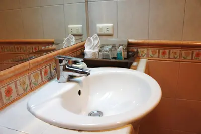 a white sink in a bathroom with a mirror at Safari Beach Hotel Patong in Patong Beach