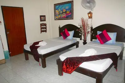 two beds in a hotel room with red pillows at Seaworld Guesthouse in Ao Nang Beach