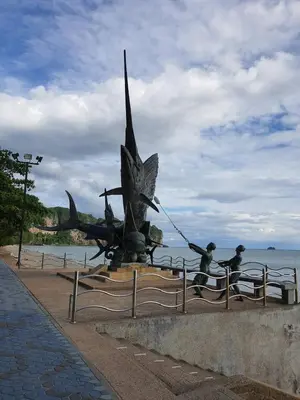 a statue of people on the beach near the water at Seaworld Guesthouse in Ao Nang Beach