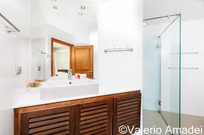 a bathroom with a sink and a glass shower at KB Apartments Karon Beach by PHR in Karon Beach