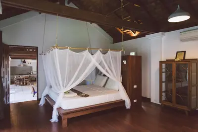 a bed with a canopy in a room at Koyao Bay Pavilions - Beach Resort and Pool Villas in Ko Yao Noi