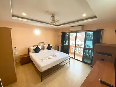a bedroom with a bed with white sheets and a window at Star Guesthouse in Patong Beach