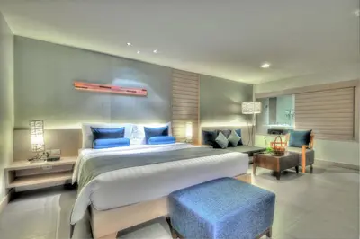 a bedroom with a large bed with blue pillows at ASHLEE Heights Hotel Patong in Patong Beach