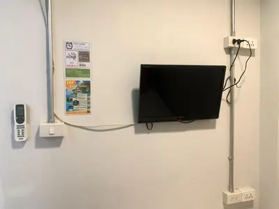 a flat screen tv hanging on a wall at Sleep Sheep Phuket Hostel SHA in Phuket Town