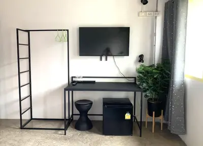 a black desk with a television on a wall at Sleep Sheep Phuket Hostel SHA in Phuket Town